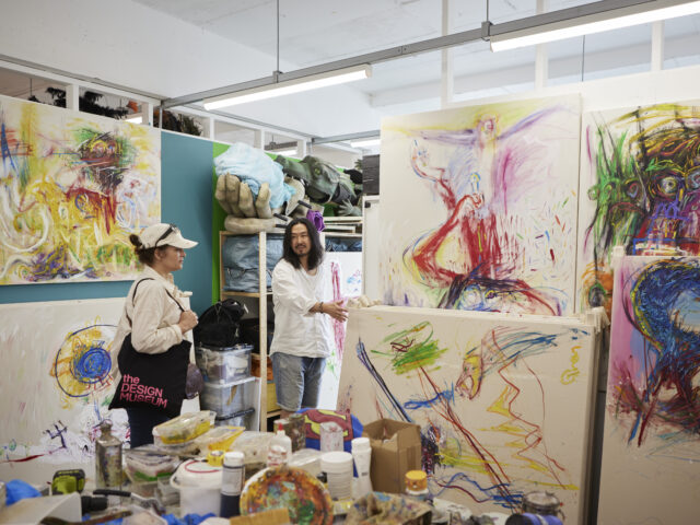 Two people in a London art studio, with bright abstract paintings.